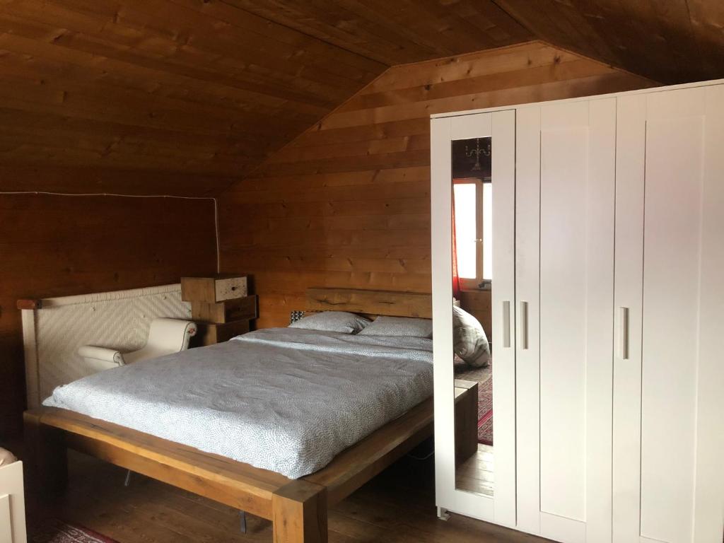 a bedroom with a bed and a white cabinet at Chalet Alpin suisse in Veysonnaz
