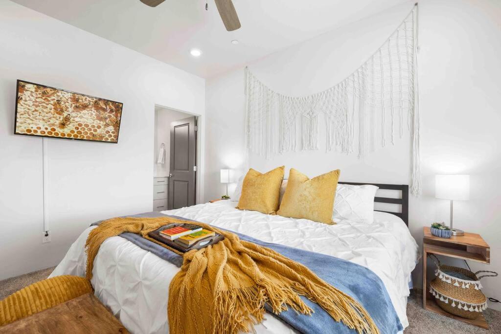 a white bedroom with a large bed with yellow pillows at The True Badger Honey House in Ephraim