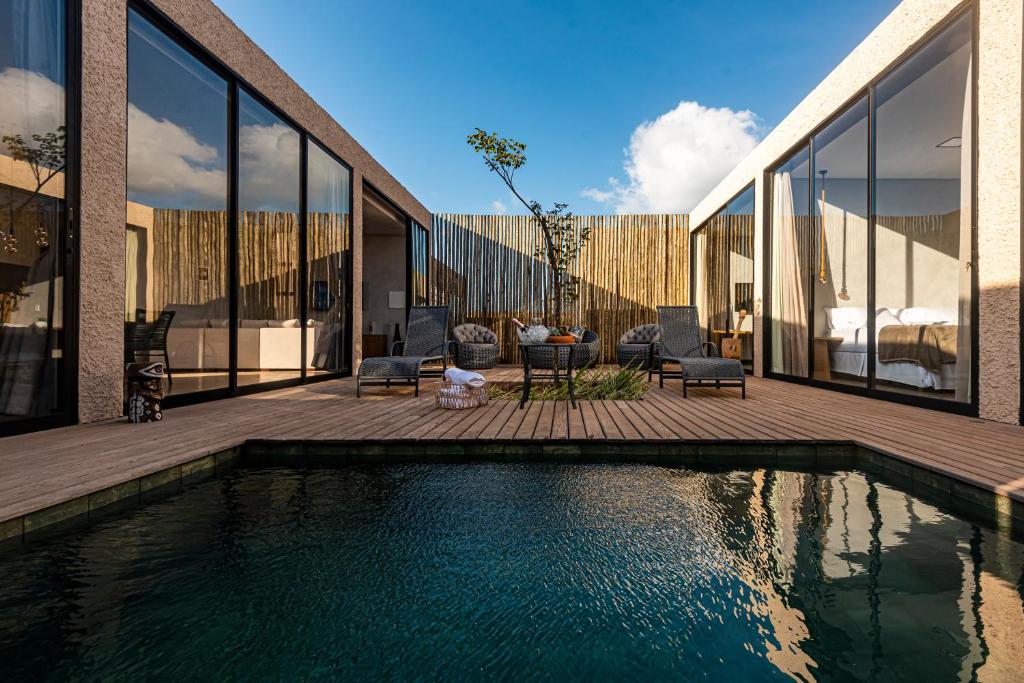 a house with a swimming pool next to a building at Uhane Luxury Villas in São Miguel do Gostoso