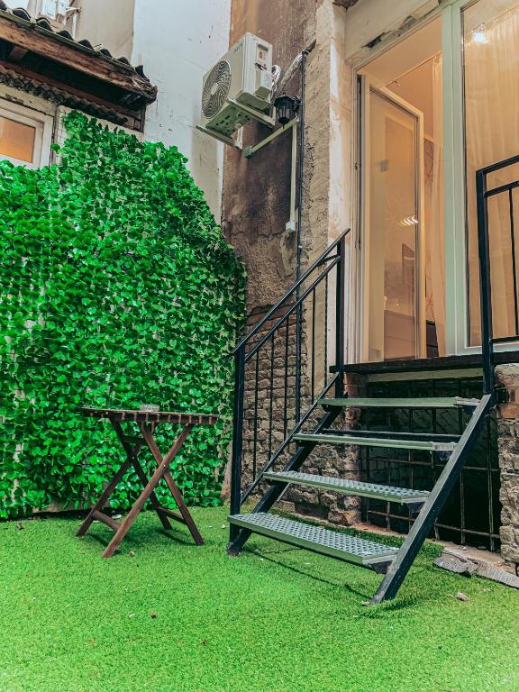 klatka schodowa i ławka obok zielonej ściany w obiekcie SZONDI Heroes Square w Budapeszcie