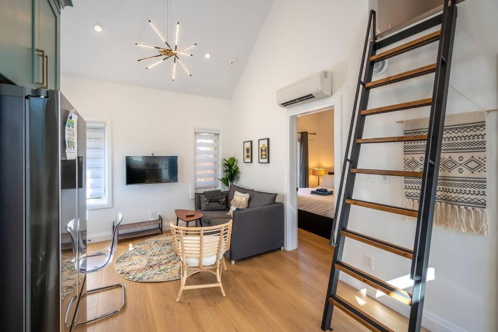 ein Wohnzimmer mit einer Treppe und einem Wohnzimmer in der Unterkunft Stylish and Cozy Tiny House with King bed in Kitchener