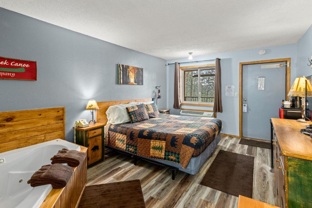 um quarto com uma cama e uma banheira em The Lookout Lodge em Eureka Springs