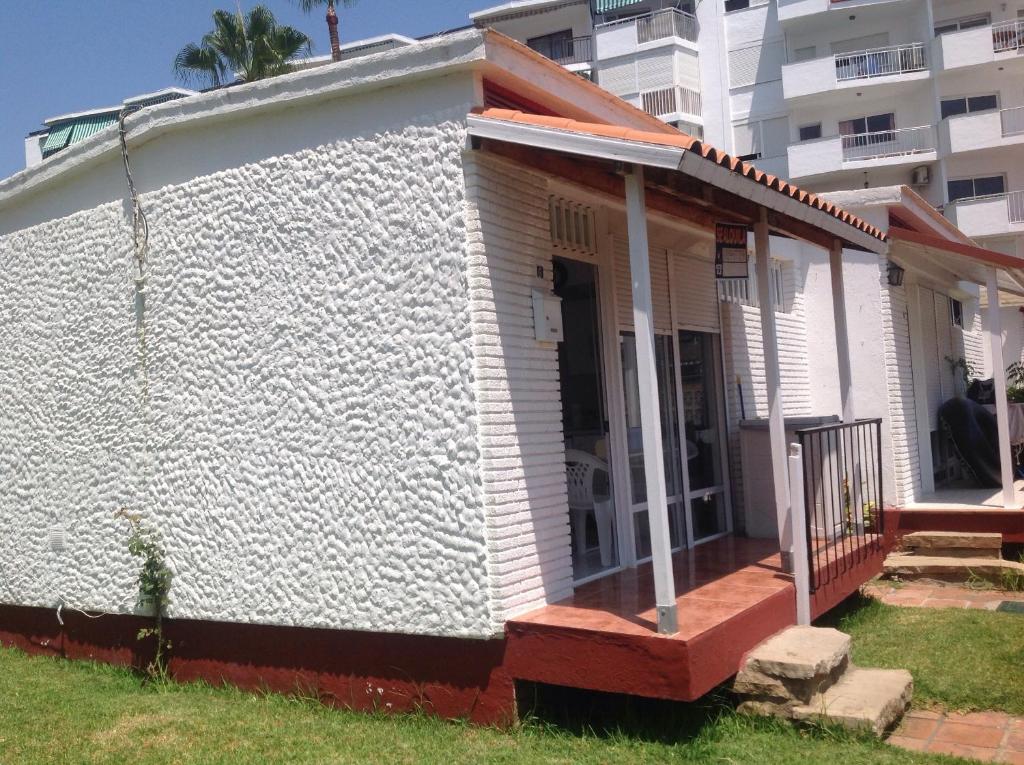 mały biały dom z gankiem przed budynkiem w obiekcie Bungalow Aloha Torres w mieście Torremolinos