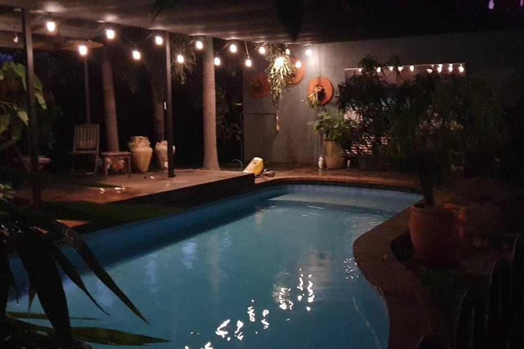a swimming pool in a backyard at night with lights at Coopers Rest Too 