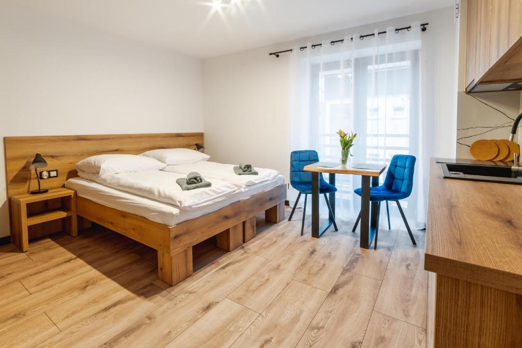 sypialnia z łóżkiem, stołem i krzesłami w obiekcie Apartamenty Pod Wyciągiem w Wiśle