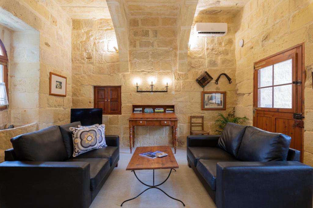 a living room with two couches and a table at Razzett Ghasri in Għasri