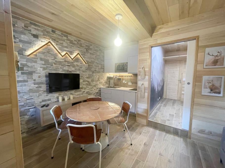 ein Esszimmer mit einem Tisch und einer Steinmauer in der Unterkunft LE NID in Cauterets