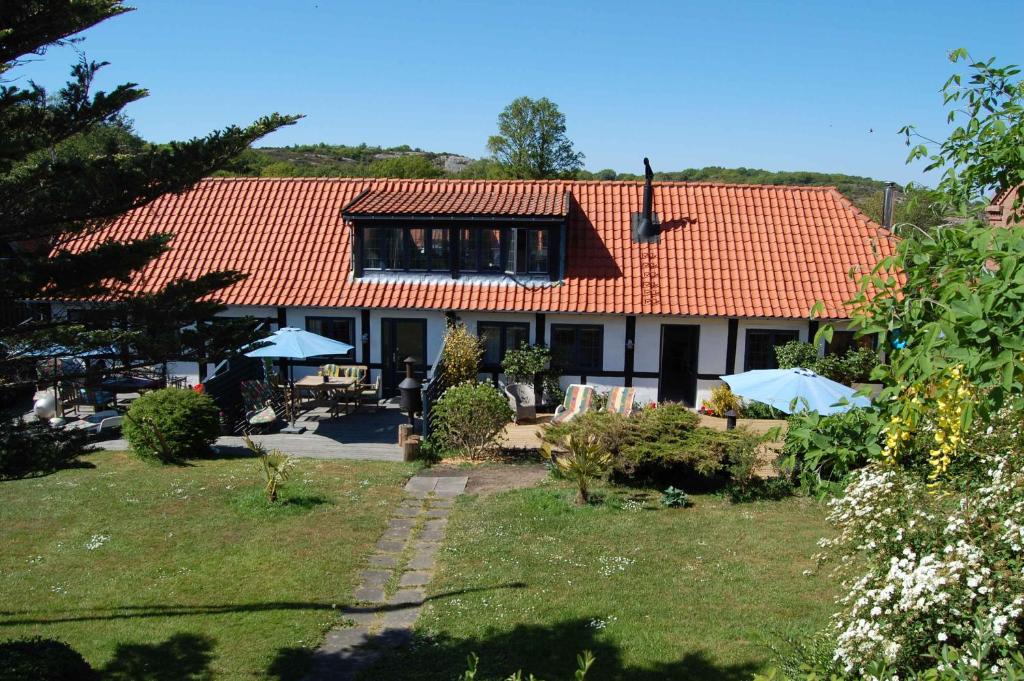 een huis met een oranje dak en een tuin bij Ferielejlighed B in Allinge