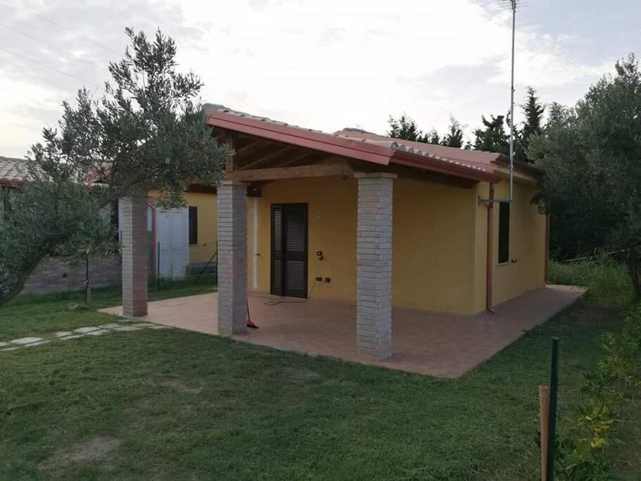 une petite maison jaune avec une allée dans l'établissement la villetta del sole, à Ovile la Marinella