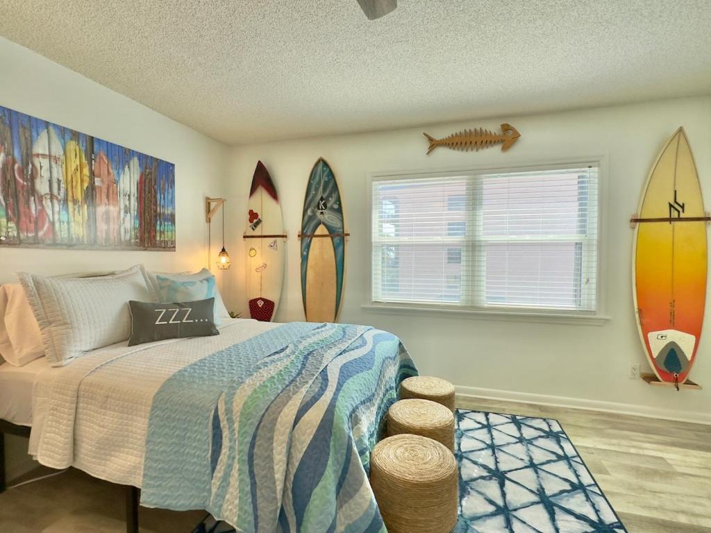a bedroom with a bed and surfboards on the wall at Pier Pressure Beachfront Wpool in Cocoa Beach