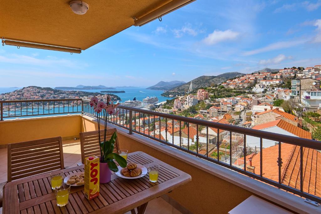 einen Balkon mit einem Tisch und Stadtblick in der Unterkunft Polina's Sunset Apartment in Dubrovnik