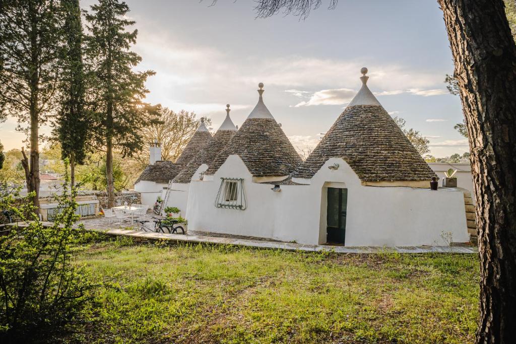 un grupo de edificios blancos con techos puntiagudos en Trulli del 1800 con Foresta, Wi-Fi e Biciclette, en Cisternino