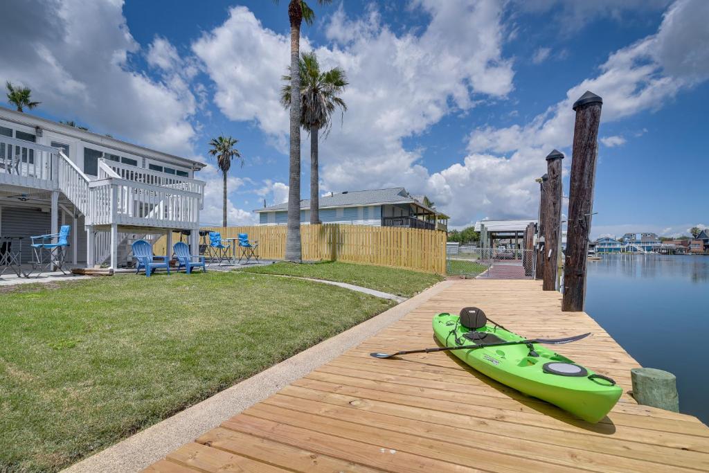 a green kayak sitting on a dock next to a house at Waterfront Galveston Bay Retreat - 4 Mi to Beach! in Galveston