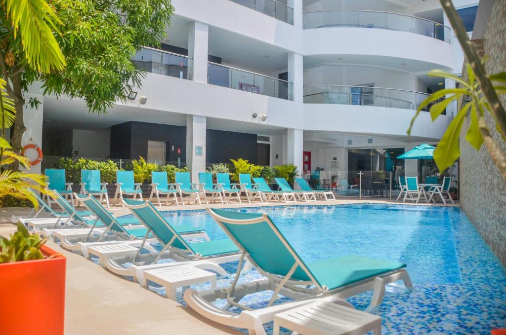 einen Pool mit Liegestühlen und ein Gebäude in der Unterkunft Portobelo Plaza de las Americas in San Andrés