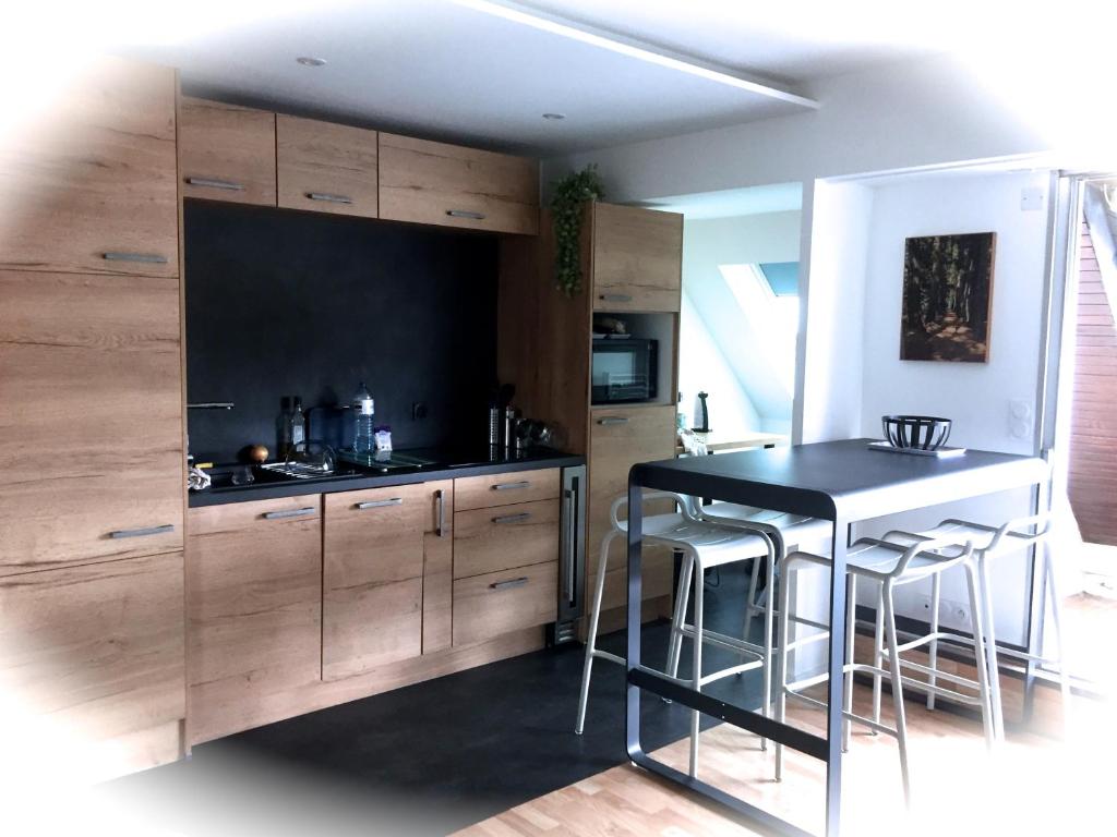 a kitchen with wooden cabinets and a black counter top at LE GALION in La Baule