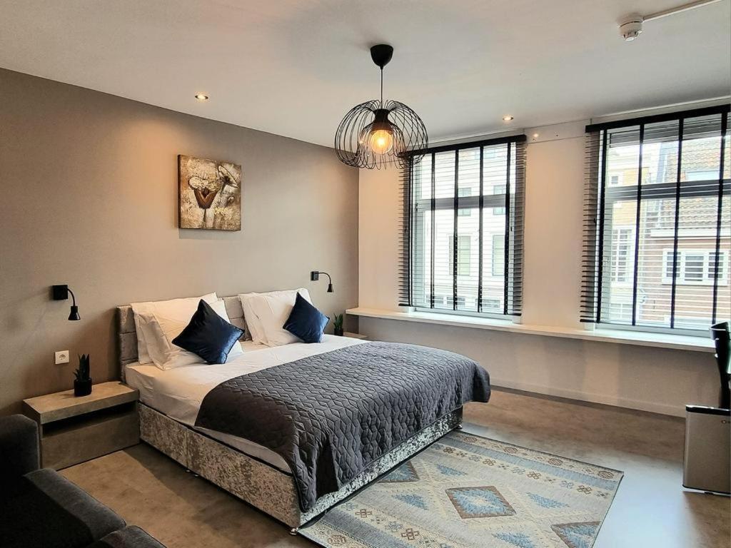 1 dormitorio con 1 cama grande con almohadas azules en Hotel De Dampoort en Middelburg