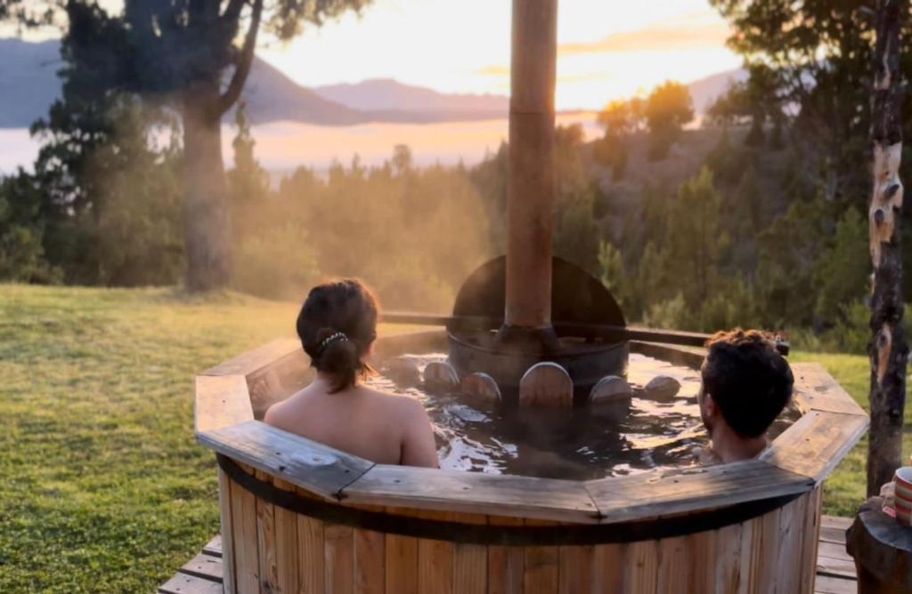 um grupo de três pessoas numa banheira de hidromassagem em Casa de Campo con tina de agua caliente em Trevelin