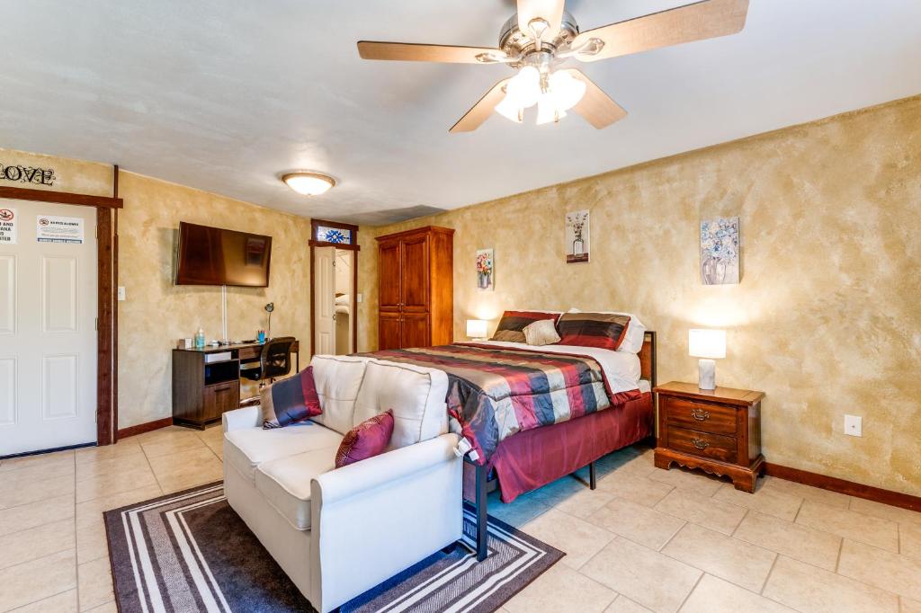 a bedroom with a bed and a couch and a ceiling fan at Hide Away Guest House in Azle