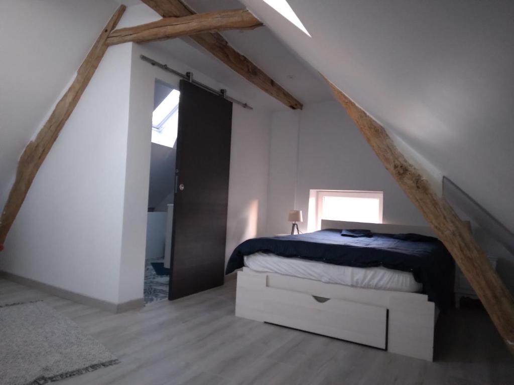 1 dormitorio con 1 cama en el ático en Sandrine en La Ferté-Saint-Aubin