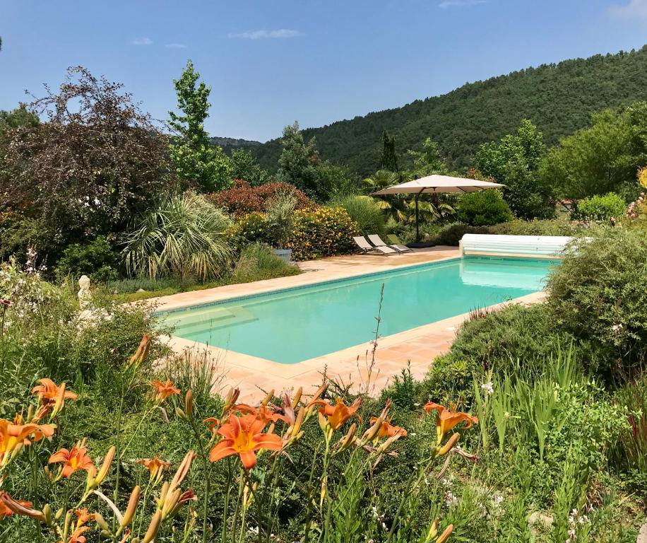 a swimming pool in a garden with flowers at Logement classé 4 étoiles avec SAUNA et vue sur le Canigou in Fuilla