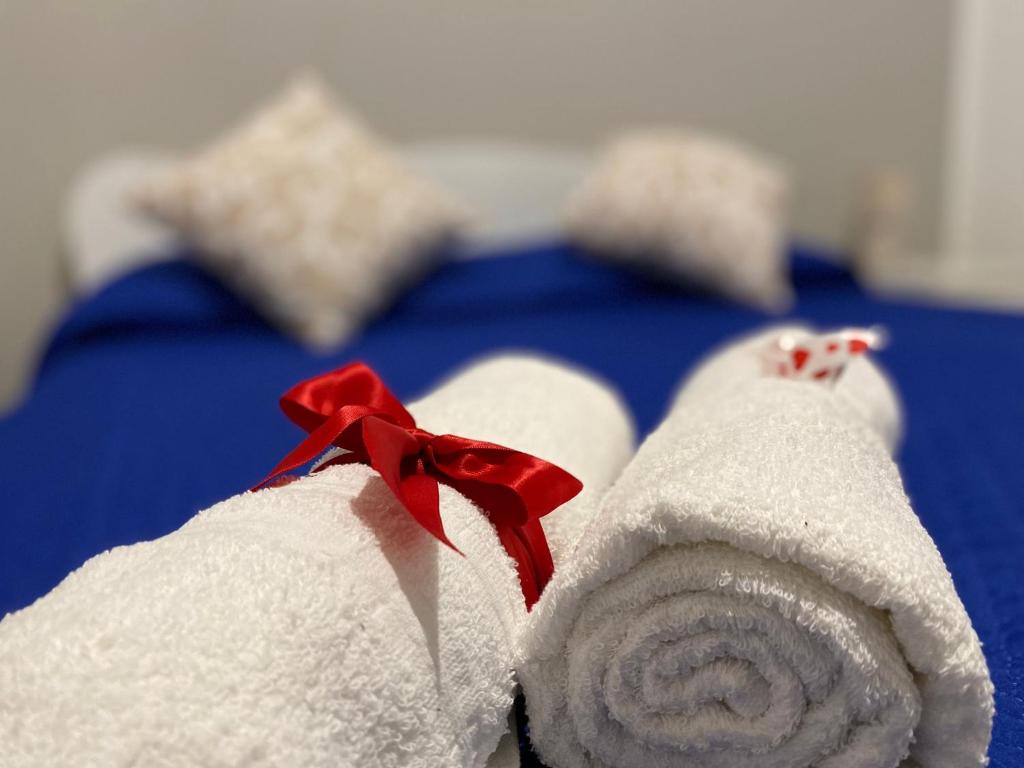 ein weißes Handtuch mit einer roten Schleife auf dem Bett in der Unterkunft HomeSea Trapani in Trapani