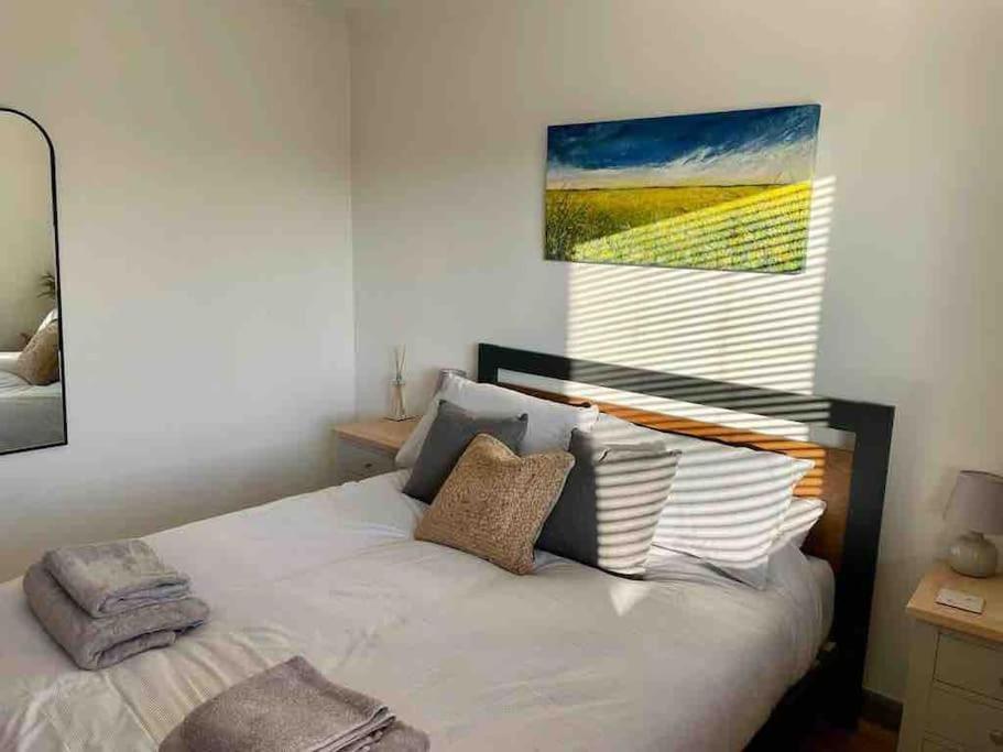 sypialnia z białym łóżkiem i obrazem na ścianie w obiekcie Modern Coastal 2 Bedroom Home to Relax and Unwind w mieście Heacham