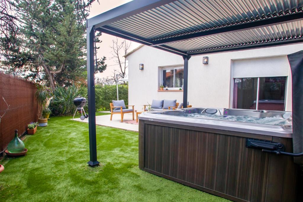 un bain à remous dans un jardin avec une pergola dans l'établissement VILLA - SPA JACUZZI - TERRASSES - CLIM & BBQ - La Valette-du-Var, à La Valette-du-Var