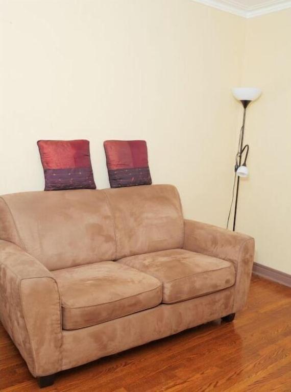 eine braune Couch mit zwei Kissen darüber in der Unterkunft Raised bungalo in Toronto