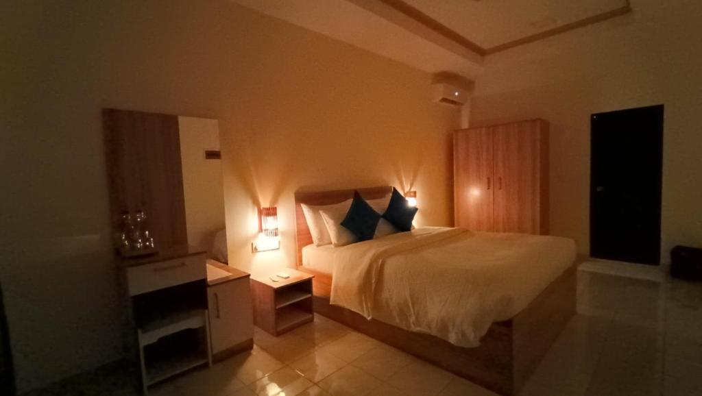 a hotel room with a bed and a night stand at Velaa Garden View, Fodhdhoo- Maldives in Fodhdhoo