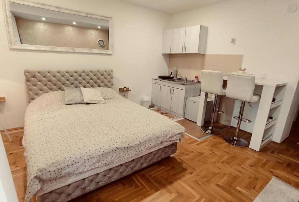 a small bedroom with a bed and a kitchen at Apartman Puket in Kraljevo