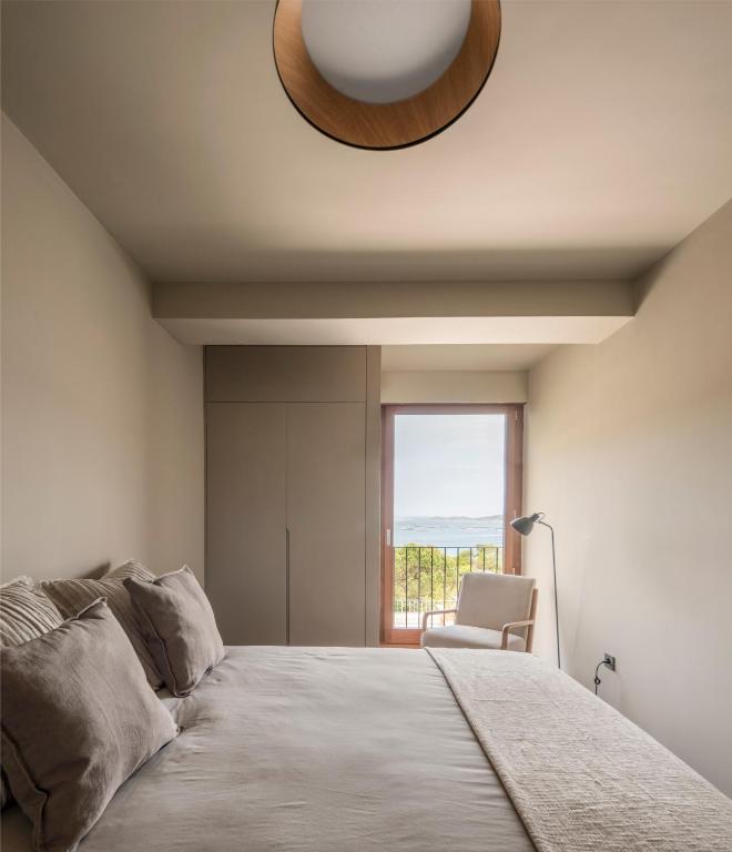 a bedroom with a large bed and a window at INSUA BEACH HOUSE in Pontevedra