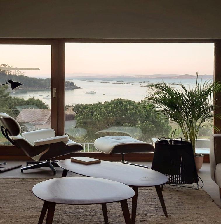 a room with a large window with a view of the water at INSUA BEACH HOUSE in Pontevedra