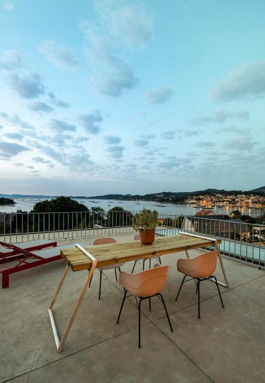a wooden table and two chairs on a balcony at INSUA BEACH HOUSE in Pontevedra