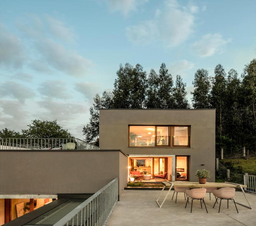 a house with a table and chairs on a patio at INSUA BEACH HOUSE in Pontevedra