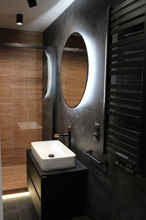 a bathroom with a sink and a mirror at Halo Green Apartament Wrocław in Wrocław