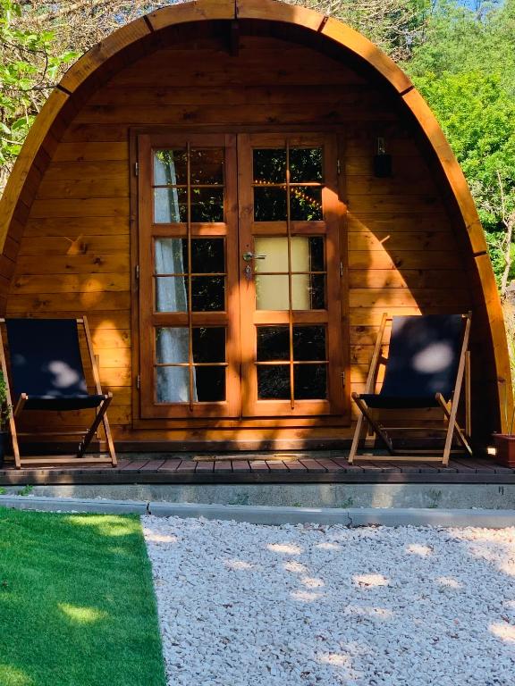 two chairs sitting in front of a cabin at Gallas Pod House in Vouzela