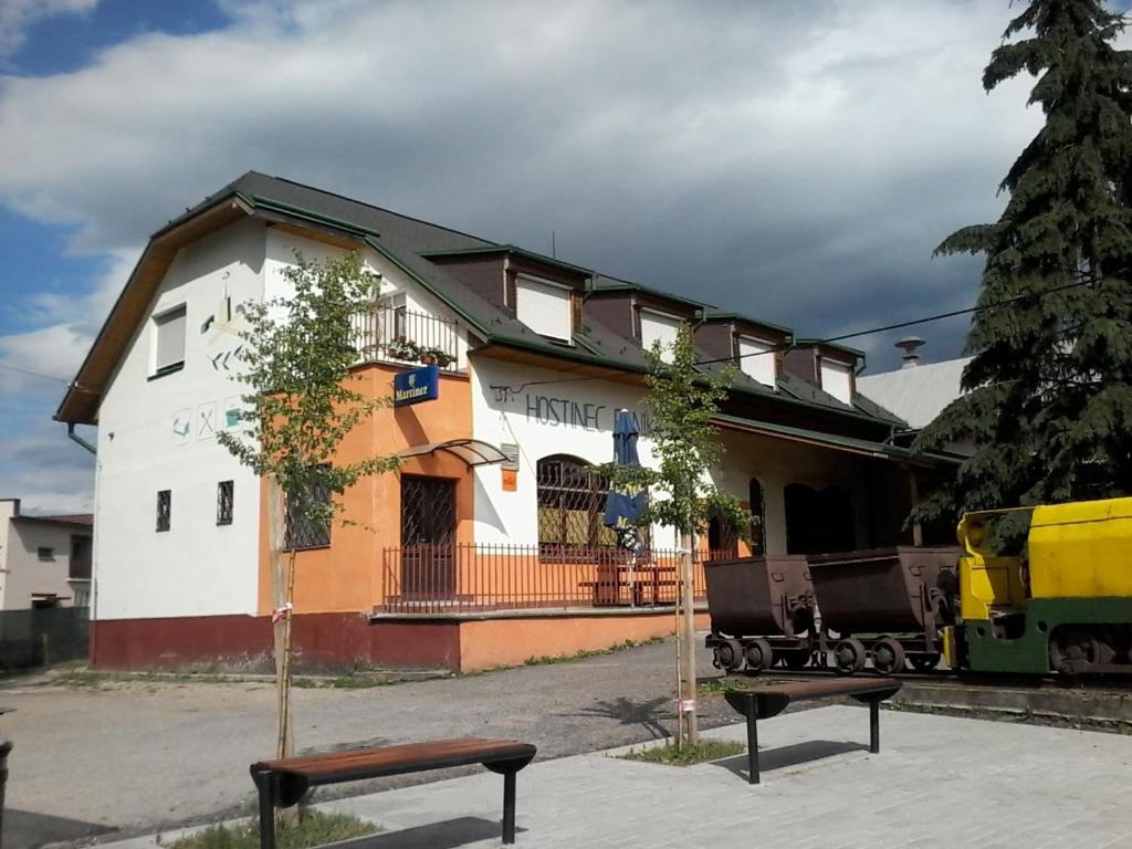 um edifício com uma estação de comboios com um banco em frente em Hostinec Banik em ľubeľa
