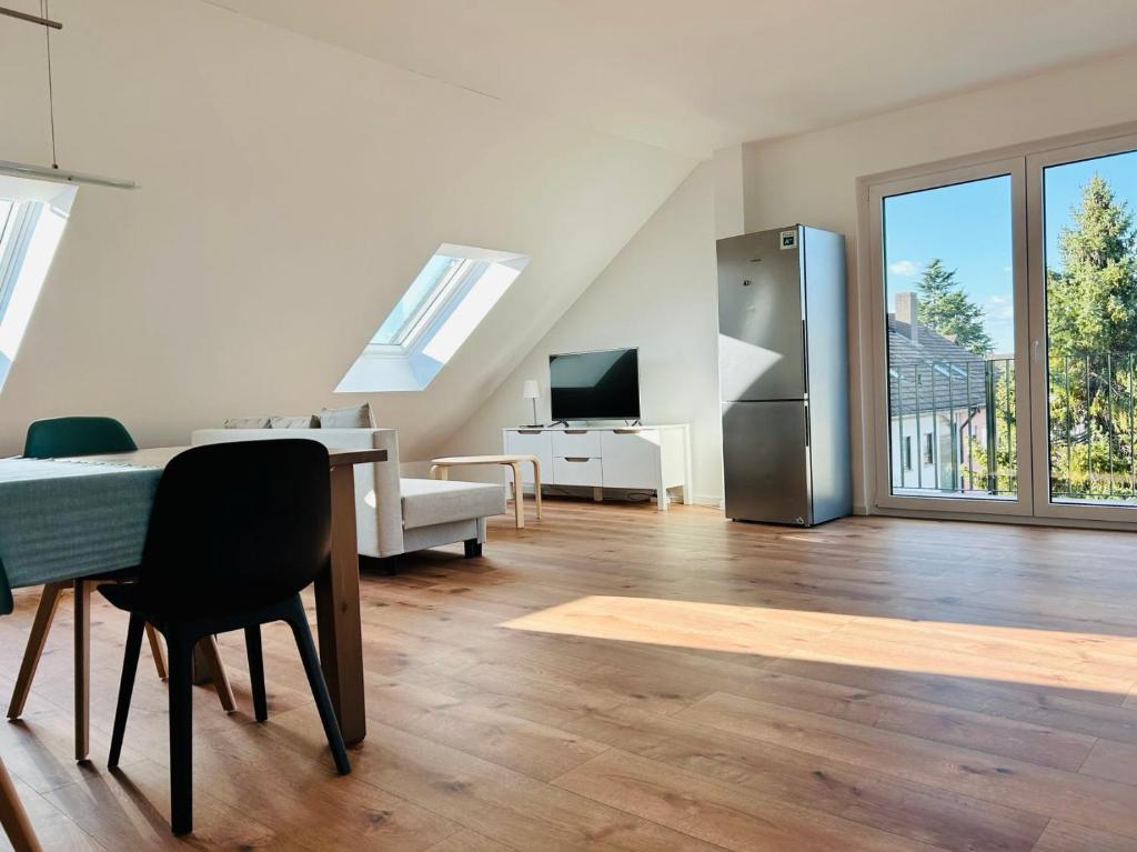 a living room with a table and a refrigerator at Ruheoase - Premium Suite in Karlsruhe