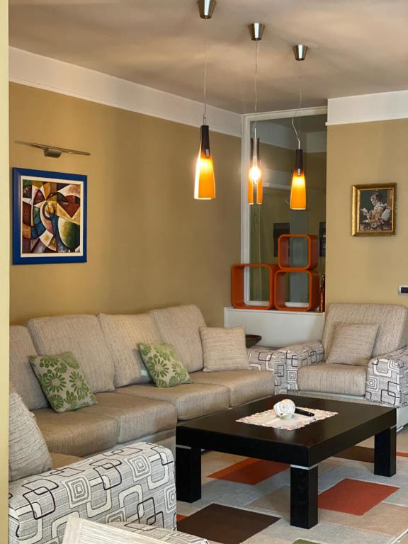 ein Wohnzimmer mit einem Sofa und einem Couchtisch in der Unterkunft Sunshine Place in Elbasan