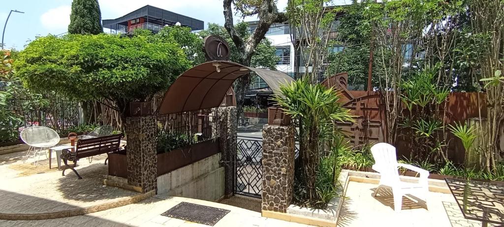 un jardín con una valla, una silla y un banco en Hotel Don Alfonso, en Pereira