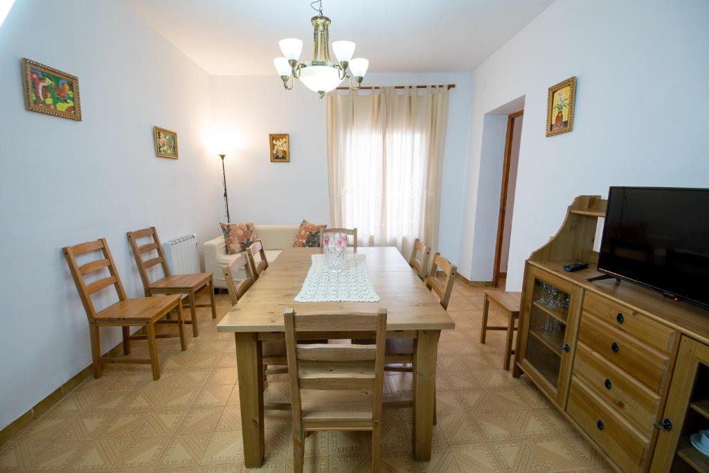 ein Esszimmer mit einem Tisch, Stühlen und einem TV in der Unterkunft Apartamento Paco entre Valencia y Castellón in Benafer