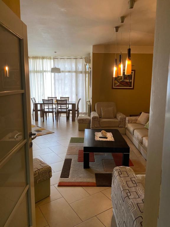 a living room with a couch and a table at Sunshine Place in Elbasan