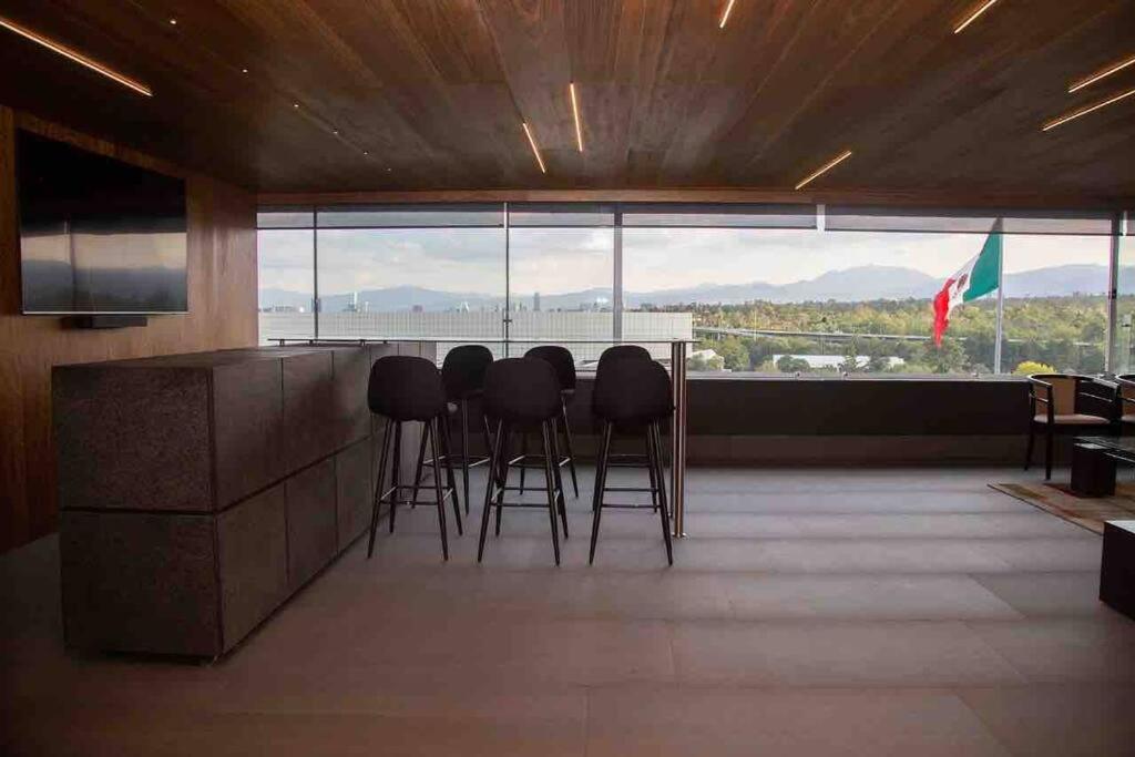 a bar with stools in a room with a view at Alojamiento de lujo con la mejor vista de Polanco in Mexico City