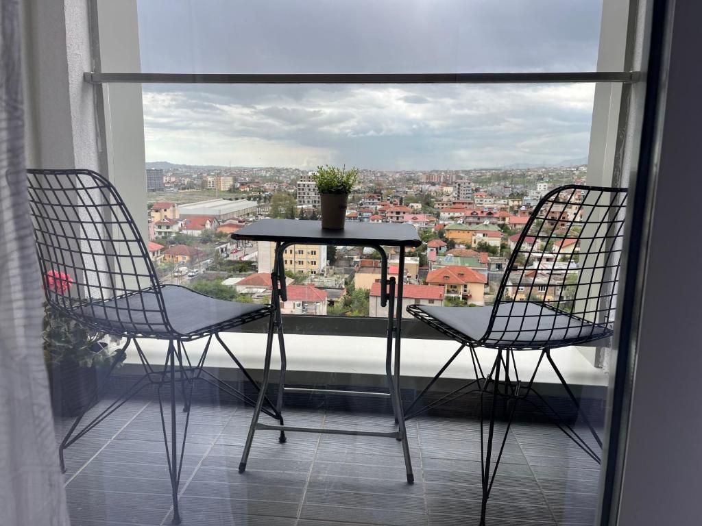 two chairs and a table on a balcony with a view at Comfy Nest Apartment- free parking in Tirana