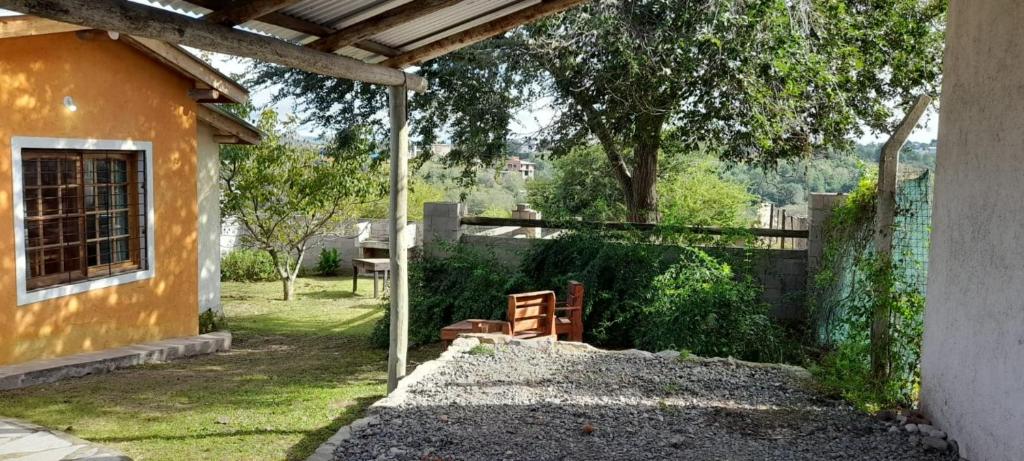 a backyard with a house and a fence at Casas HG - Cabañas sencillas y cómodas en las Sierras - Ideal para trabajar - Cochera - Aceptamos mascotas in Huerta Grande