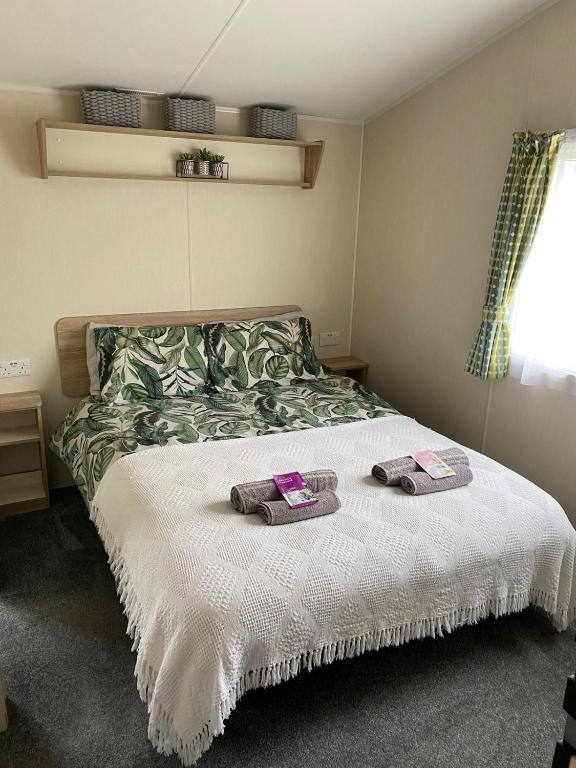 a bedroom with a bed with two towels on it at Yogi's Space in Birchington