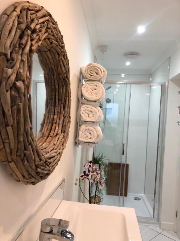 a bathroom with a mirror and a pile of towels at Ocean Drive Boutique Apartment complimentary Tray in Brean
