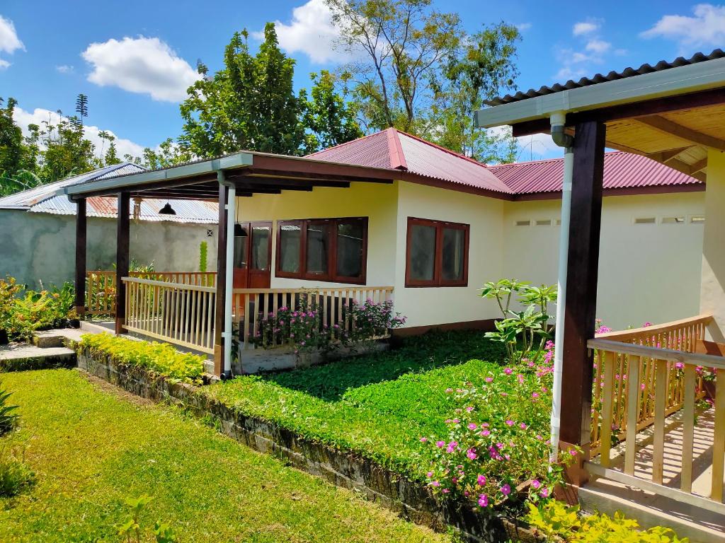 una casa con techo rojo en Ilasan cottage., en Tomohon