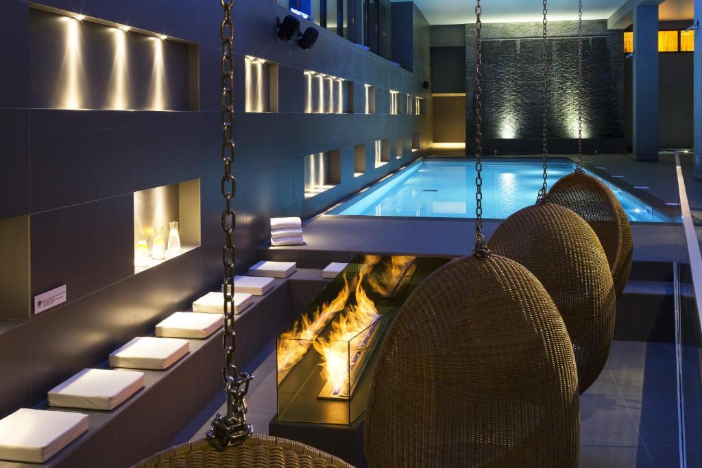 a hotel pool with chairs and a fireplace at Appartements de l&#39;Héliopic in Chamonix
