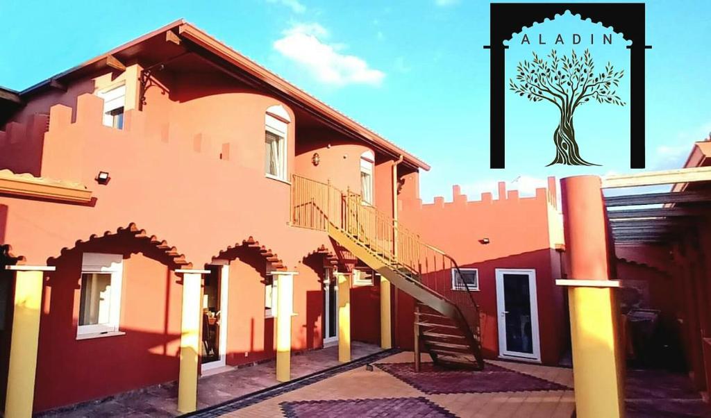 un bâtiment avec un arbre sur son côté dans l'établissement Aladin Comfort Country House, à Campinho